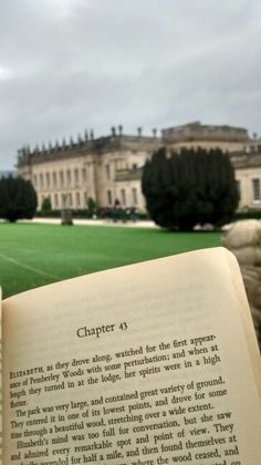 an open book sitting in front of a large building