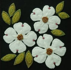 three white flowers with green leaves on a black background