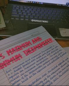 a pile of papers sitting on top of a desk next to a laptop computer