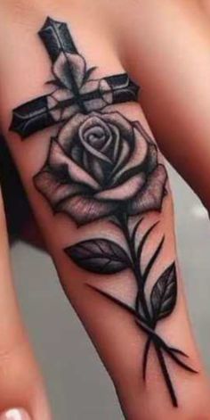 a cross and rose tattoo on the wrist