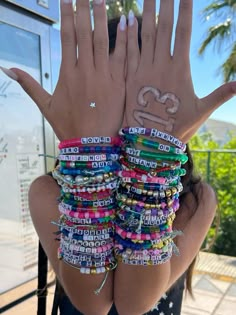 a woman with her hands in the air and some bracelets on her arm,