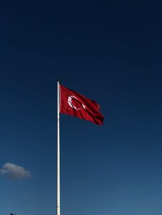 a flag flying in the wind on top of a building