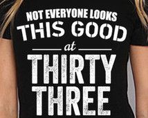 a woman wearing a t - shirt that says not everyone looks this good at thirty three