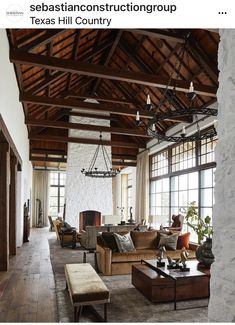 a living room filled with furniture and large windows