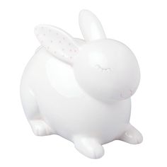 a white ceramic rabbit with pink dots on it's ears and tail, sitting in front of a white background