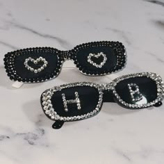 three pairs of sunglasses with the letters h and b on them sitting on a marble surface