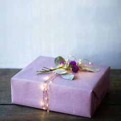 a purple wrapped gift with flowers and lights