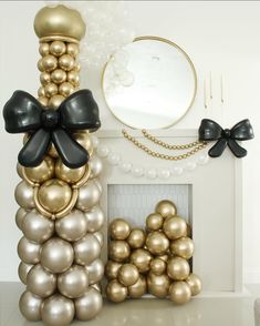 balloons are stacked on top of each other in front of a fireplace with a mirror