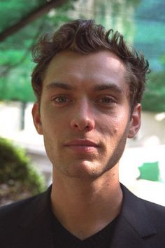 a young man in a suit and tie looking at the camera