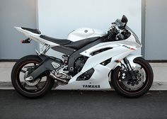 a white motorcycle parked in front of a building