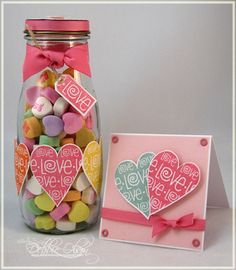 a jar filled with lots of candy next to a card