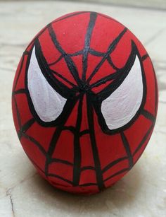 a close up of a spiderman ball on a tile floor with eyes painted on it