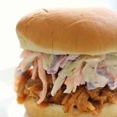 a pulled pork sandwich on a bun with coleslaw