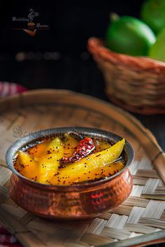 a bowl filled with food on top of a wooden tray next to a basket full of fruit