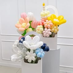 there are many balloons in the shape of flowers on this white vase, and one is shaped like a flower