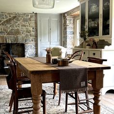 a dining room table with chairs and a rug on the floor in front of it