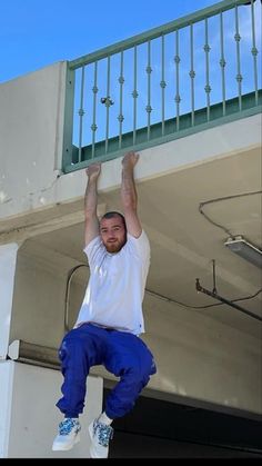 a man standing on top of a building while holding onto the side of his head