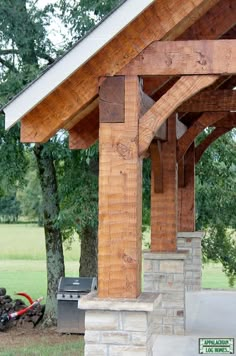 an outdoor covered patio with grill and picnic table