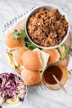 pulled pork sandwiches with coleslaw, slaw and pickles on the side