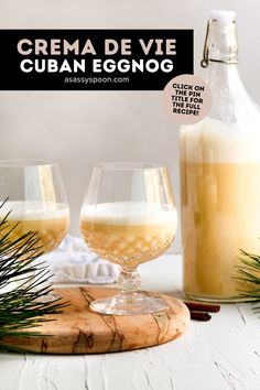 two glasses filled with white wine sitting on top of a wooden tray next to a bottle