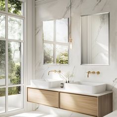 a bathroom with two sinks and mirrors on the wall next to each other in front of large windows