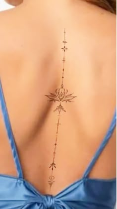 the back of a woman's neck with an arrow and compass tattoo on it