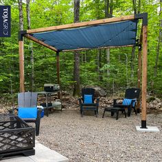 an outdoor area with chairs, tables and a pergolated gazebo in the woods