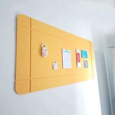 a bulletin board with sticky notes and magnets attached to the wall in an office