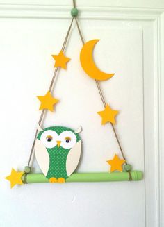 an owl on a branch with stars hanging from it