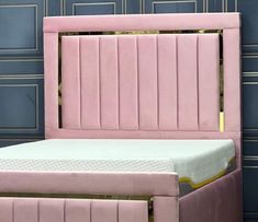 a pink bed with gold trim and headboard