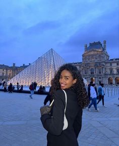 a woman standing in front of a pyramid