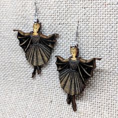 Beautiful Victorian Lady in her elegant bat costume. Pair with our Bat Girl Necklace! • Made in United States • Weight: 0.2 oz (4.5 g) • Measures approx 1.75 x 2 inches • Made of lightweight wood. • Hypoallergenic stainless steel ear wires. • Laser cut and printed with a matte glaze. Bat Jewelry, Bat Girl, Trollbeads Bracelet, Bat Earrings, Laser Cut Earrings, Earrings Halloween, Witch Jewelry, Pandora Bracelet Charms, Skull Earrings