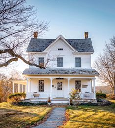 a white house sitting on top of a lush green field