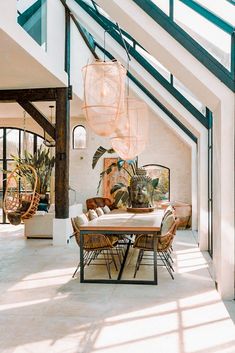 a dining room table with chairs and hanging plants in the middle of an open floor plan