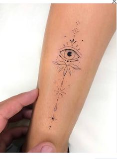 someone holding their arm with an eye tattoo on it