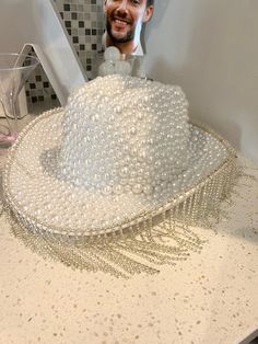 The perfect hat to hit the town running on your bachelorette. This hand made cowboy hat is covered in white pearls and finished with a fringe. Don't miss out on this beautiful custom hat! Diy Bedazzled Cowboy Hat, Pearl Cowboy Hat, White Fedora Mini Hat For Party, White Beaded Hat With Short Brim, White Beaded Short Brim Hat, White Beaded Curved Brim Hat, White Beaded Hats For Festival, Bridal Cowboy Hat, Bedazzled Cowboy Hat