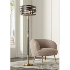 a chair sitting next to a lamp on top of a rug in a living room