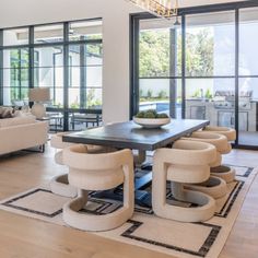 a living room filled with furniture and lots of glass doors leading to an outside patio