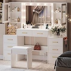 a white vanity with lights on it in a room next to a bed and window