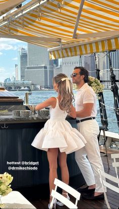 a man and woman standing at an outdoor bar