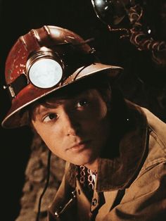 a man wearing a fireman's hat with a light on his head and a chain around his neck