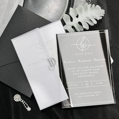 the wedding stationery is laid out on top of an envelope and some other items