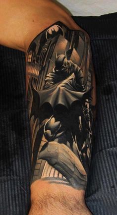 a man's arm with batman tattoos on it