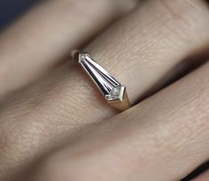 a close up of a person's hand with a diamond ring on their finger