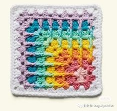 a colorful crochet square with flowers on the bottom and one flower in the middle