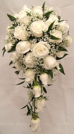 a bouquet of white roses and baby's breath on a white background with greenery