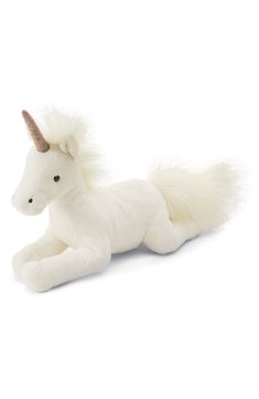 a white stuffed unicorn laying down on the ground