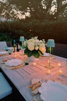 a table set for dinner with candles and flowers