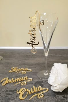 a wine glass with the word garni on it next to a white flower