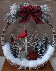 a snow globe with a cardinal and pine cones